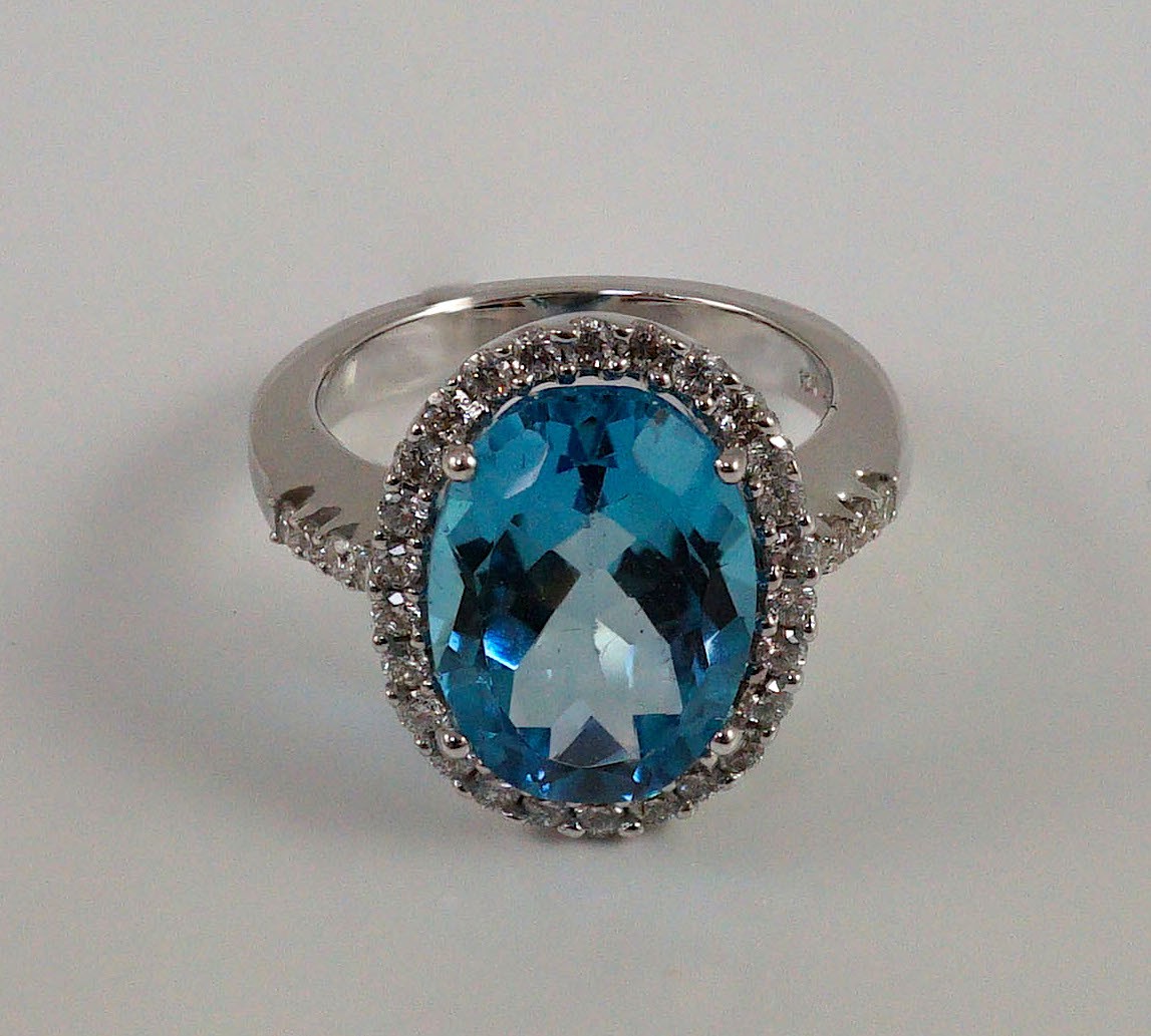 A modern 18k white gold, blue topaz and diamond oval cluster dress ring